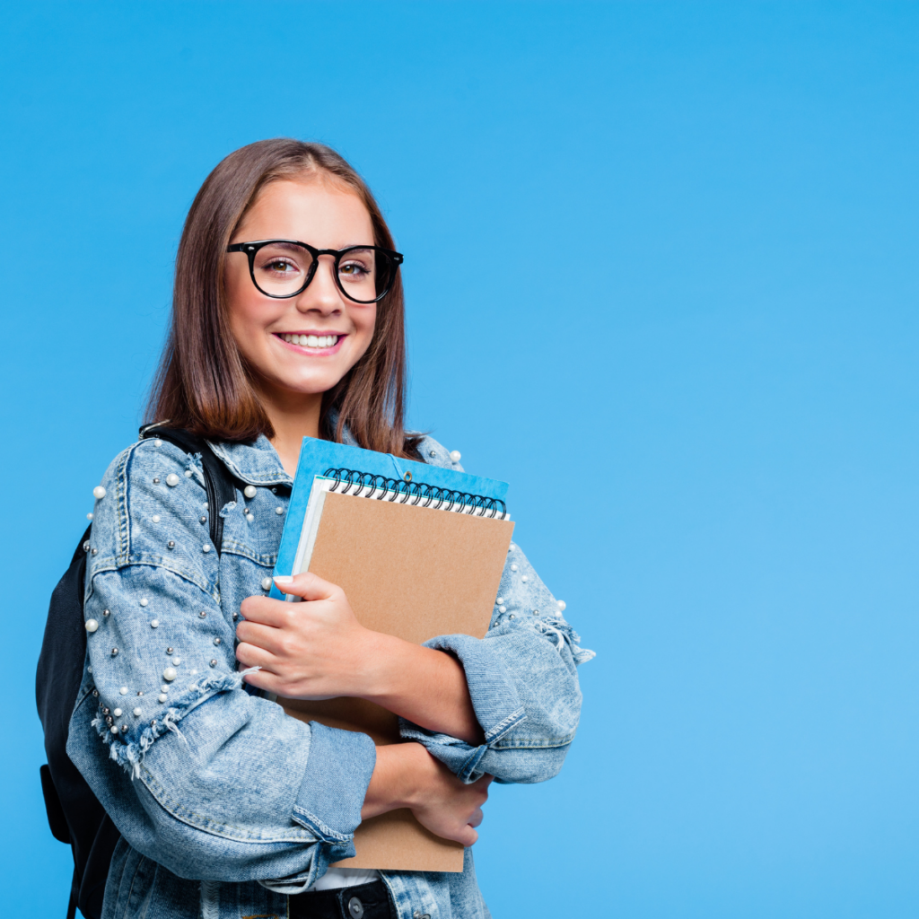 Elève souriante se préparant à sa rentrée en classe de seconde, portant ses cahiers dans les bras