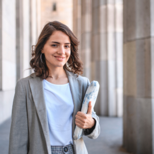 Photo d'une étudiante en faculté portant son ordinateur portable à la main, illustrant l'année de recherche de la voie professionnelle