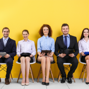 Photo de cinq jeunes candidats attendant leur entretien d'embauche pour leur premier poste